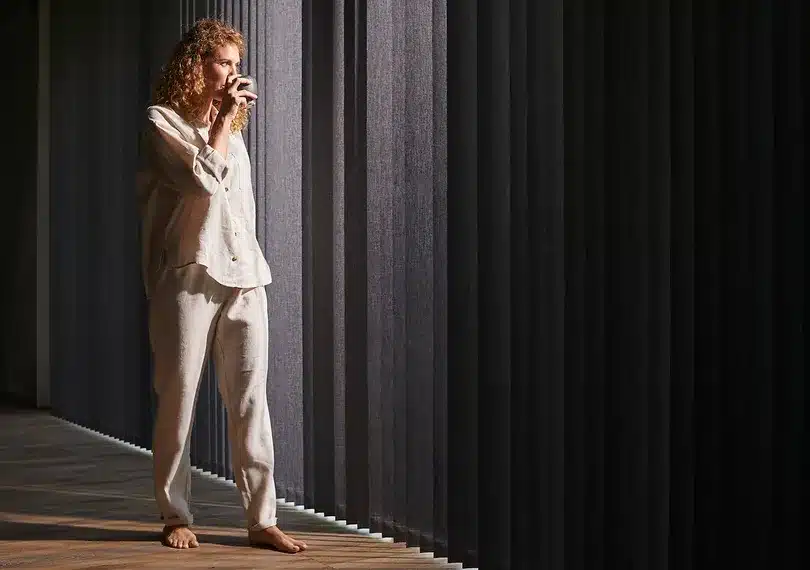 Femme devant des stores californiens noirs